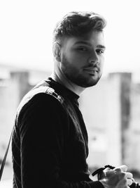 Portrait of young man standing against sky