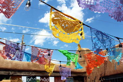 Low angle view of flags hanging on building against sky