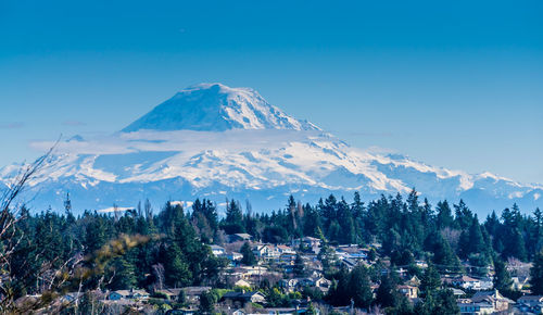 Scenic view of snowcapped mountains against blue sky during sunny day