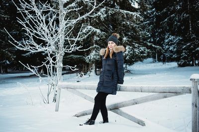 Full length of woman standing on snow covered land