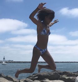 Full length of woman standing by sea against sky