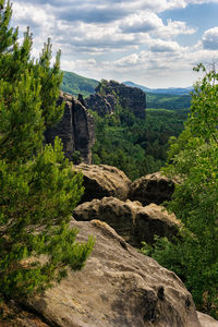 Scenic view of rock formation amidst trees against sky
