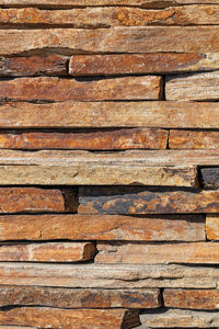 Wall, background and texture of brown old sandstone in  stack, close-up. vertical image, copy space.