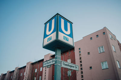 Low angle view of sign on building against clear sky