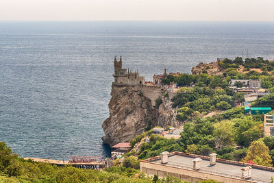 High angle view of buildings by sea against sky