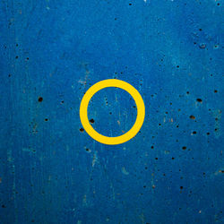 Close-up of yellow circle on blue wall