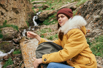 Young woman sitting on rock