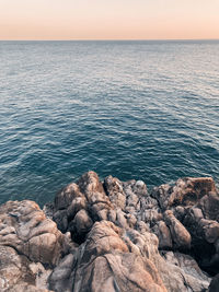 Scenic view of rocks in sea against sky in tuscany, italy