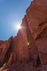 Low angle view of sun shining through rocks