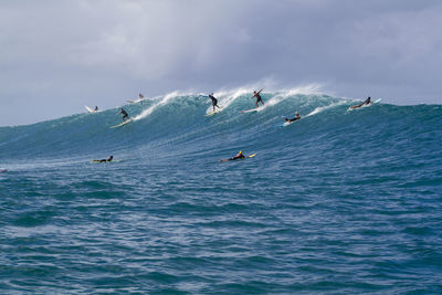 People in sea against sky