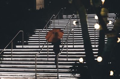 Rear view of woman standing on staircase