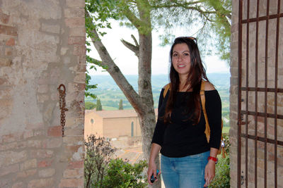Young woman in front the panorama of san gimignano, medieval tuscan city istone red bricks in italy