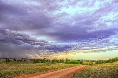 Scenic view of field against cloudy sky