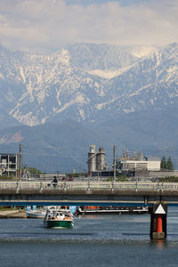 Scenic view of river by mountains against sky