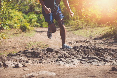 Low section of man running on land