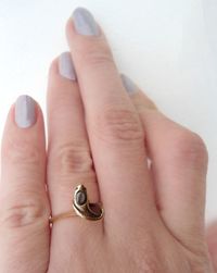 Cropped hand of woman wearing ring against wall