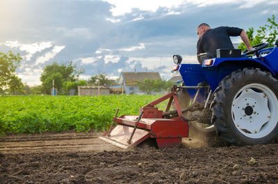 A farmer is cultivating a field before replanting seedlings. milling soil, crushing and loosening 