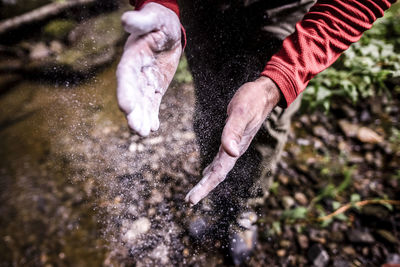 Cropped hands of man dusting chalk powder before climbing