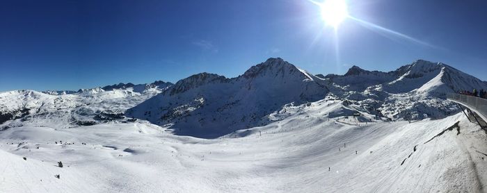 Scenic view of snowcapped mountains against blue sky