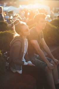 Midsection of couple sitting outdoors