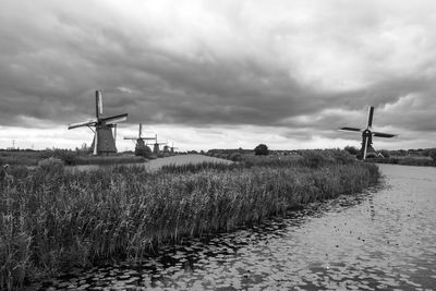 Windmills on farm against sky