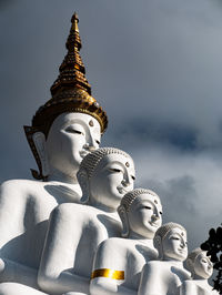 Low angle view of statue against temple against sky