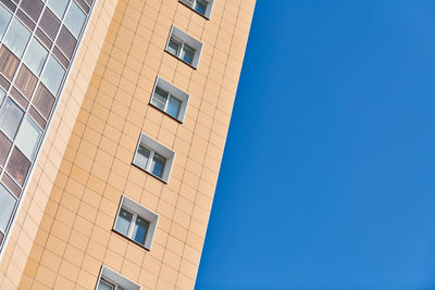 Low angle view of buildings against clear blue sky