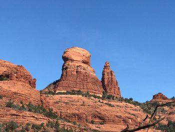 Low angle view of rock formation against clear blue sky