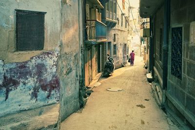 Man walking on road amidst buildings in city