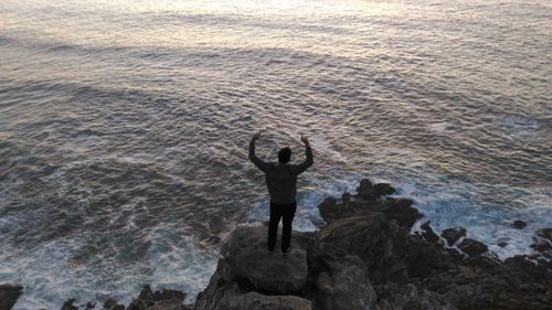 Rear view of man standing on rock