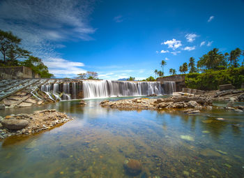 Scenic view of waterfall against sky