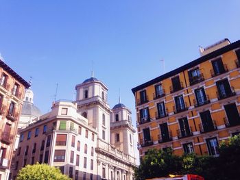 Low angle view of buildings against clear blue sky