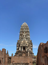 Low angle view of thai temple pagoda against blue sky