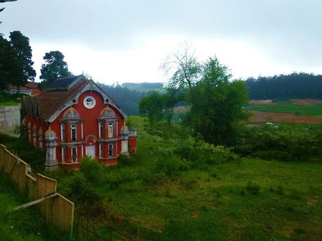 building exterior, architecture, built structure, tree, house, sky, grass, growth, green color, field, cloud - sky, nature, residential structure, landscape, church, place of worship, religion, outdoors, plant, day