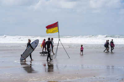 People on beach against sky