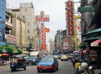 Cars on city street by buildings