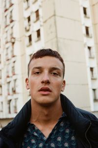 Portrait of young man against building in city