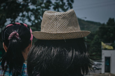 Rear view of woman with hat against trees