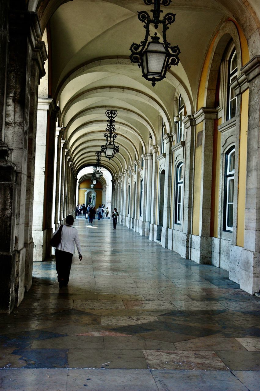 PEOPLE WALKING ON CORRIDOR OF BUILDING