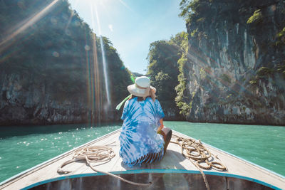 Man sitting in boat against sky