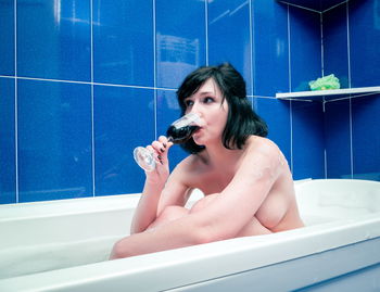 Portrait of young woman in bathtub