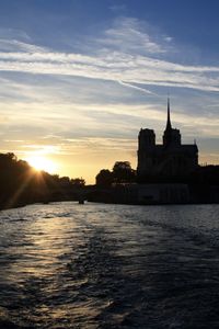 Sunset over river with buildings in background