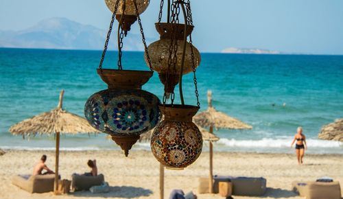 People on beach by sea against sky