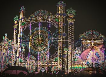 Low angle view of illuminated lights against sky at night