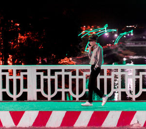 Man talking on mobile phone in illuminated city at night