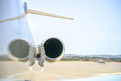 Airplane on airport runway against clear sky