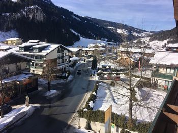 High angle view of houses by snowcapped mountain against sky