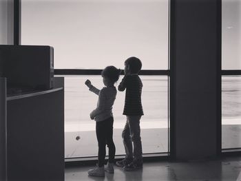 Children standing against window