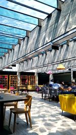 Empty chairs and tables at sidewalk cafe in city