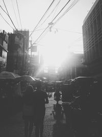 People walking on city street against sky